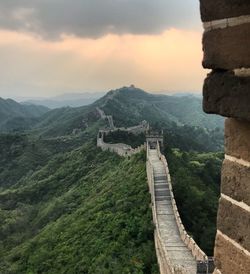 Great wall of china on mountains against cloudy sky during sunset