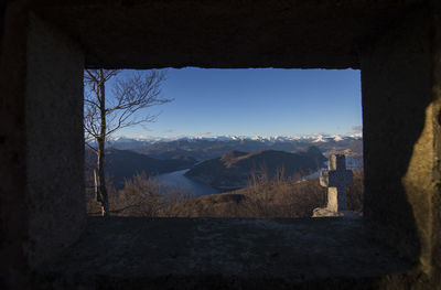 Scenic view of mountains seen through window of historic building