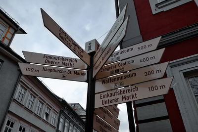 Low angle view of road sign against built structures