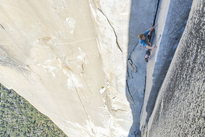 Rock climbing clipping rock while lead climbing the nose on el capitan