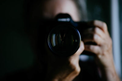 Close-up of woman photographing through camera at home