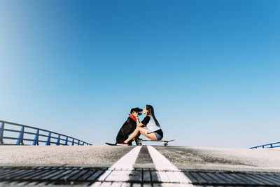 People at observation point against clear blue sky