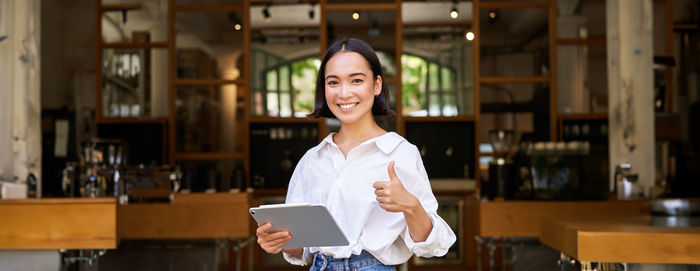 Portrait of young woman standing in library