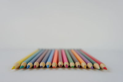 Close-up of multi colored pencils against white background