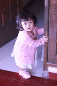 Portrait of cute girl standing on floor at home