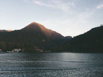 Scenic view of lake by mountains against sky