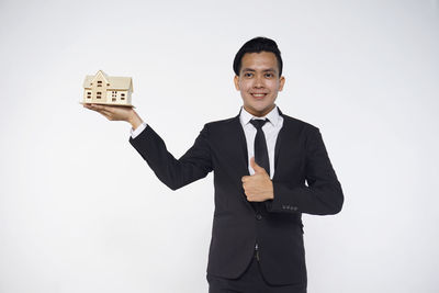 Portrait of smiling man standing against white background