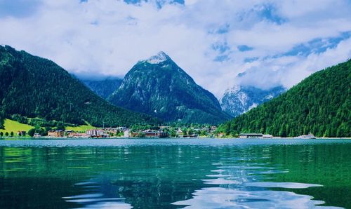 Scenic view of lake by mountains against sky