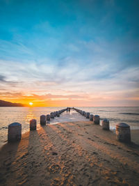 Bridge over sea against sky during sunset