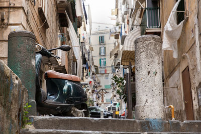 Motor scooter parked by buildings in city