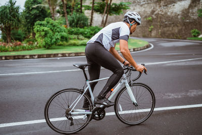 Rear view of man riding bicycle on street