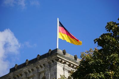 Low angle view of german flag on building against sky