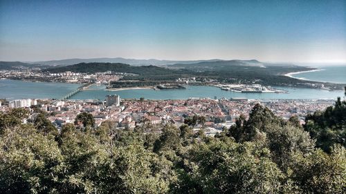 Scenic view of sea by city against clear sky