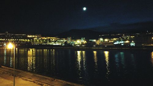 Illuminated buildings against sky at night