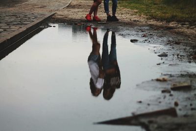 Reflection of friend in puddle