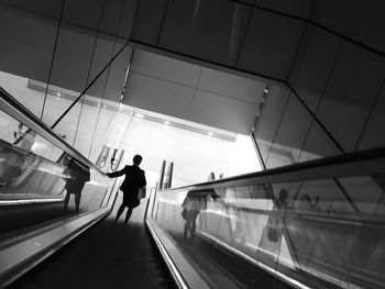 Rear view of woman walking on railroad station