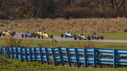 Full frame view of open-wheel race cars on a racetrack