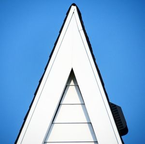 Low angle view of modern building against clear blue sky
