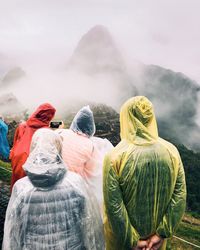 People looking at mountains during foggy weather