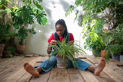 Side view of man sitting by plants