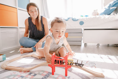 Mother and daughter sitting on toy at home