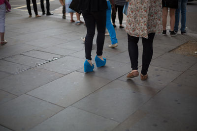 Low section of people walking on tiled floor