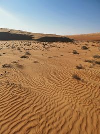 Sand dune in desert against clear sky