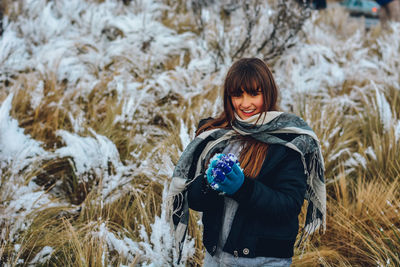 Portrait of smiling woman on snow covered field