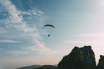 Low angle view of person paragliding against sky