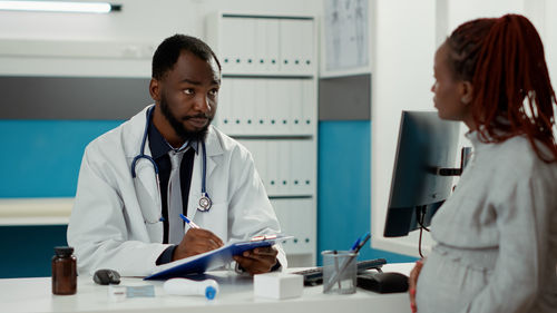 Pregnant woman consulting doctor at clinic