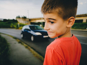 Boy standing on sidewalk