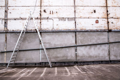 Ladder against wall of abandoned building