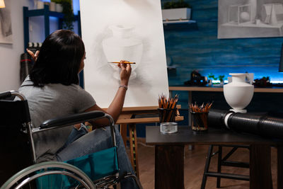 Rear view of woman painting at studio