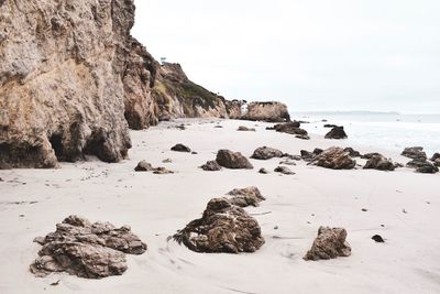 Rocks on beach against sky