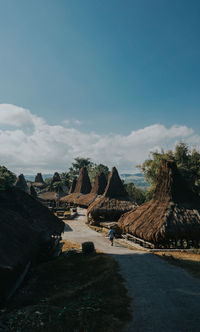 Panoramic shot of road amidst trees against sky