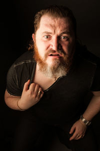 Portrait of man wearing mask against black background