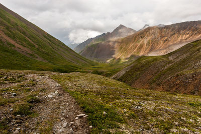 Scenic view of valley and mountains against sky