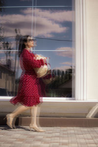 Rear view of woman standing by window