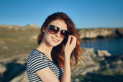 Portrait of smiling young woman wearing sunglasses