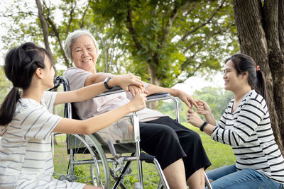 Women sitting on people at park