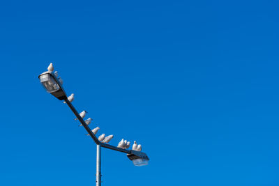 Low angle view of street light against clear blue sky