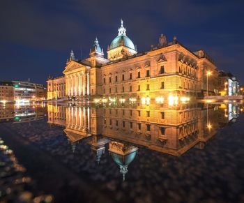 Illuminated building against sky at night