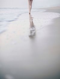 Low section of woman walking on water