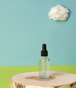 Facial cosmetic product on a wooden podium with a cotton cloud. copy space, front view.