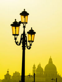 Low angle view of street light against building at sunset