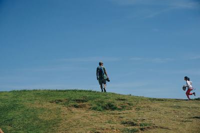 People standing on field against sky