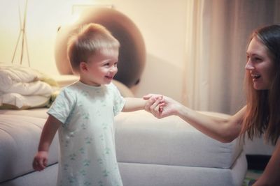 Mother and baby boy playing in bedroom