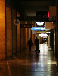 People walking in illuminated corridor