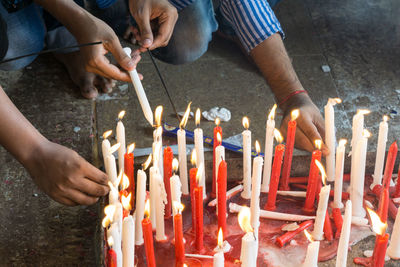 People igniting candle in church