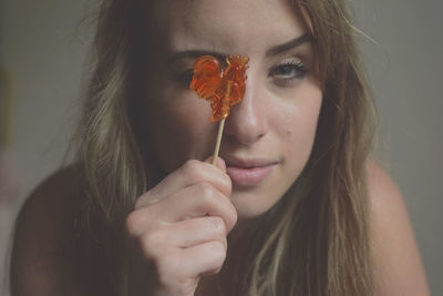 Close-up of beautiful young woman holding lollipop